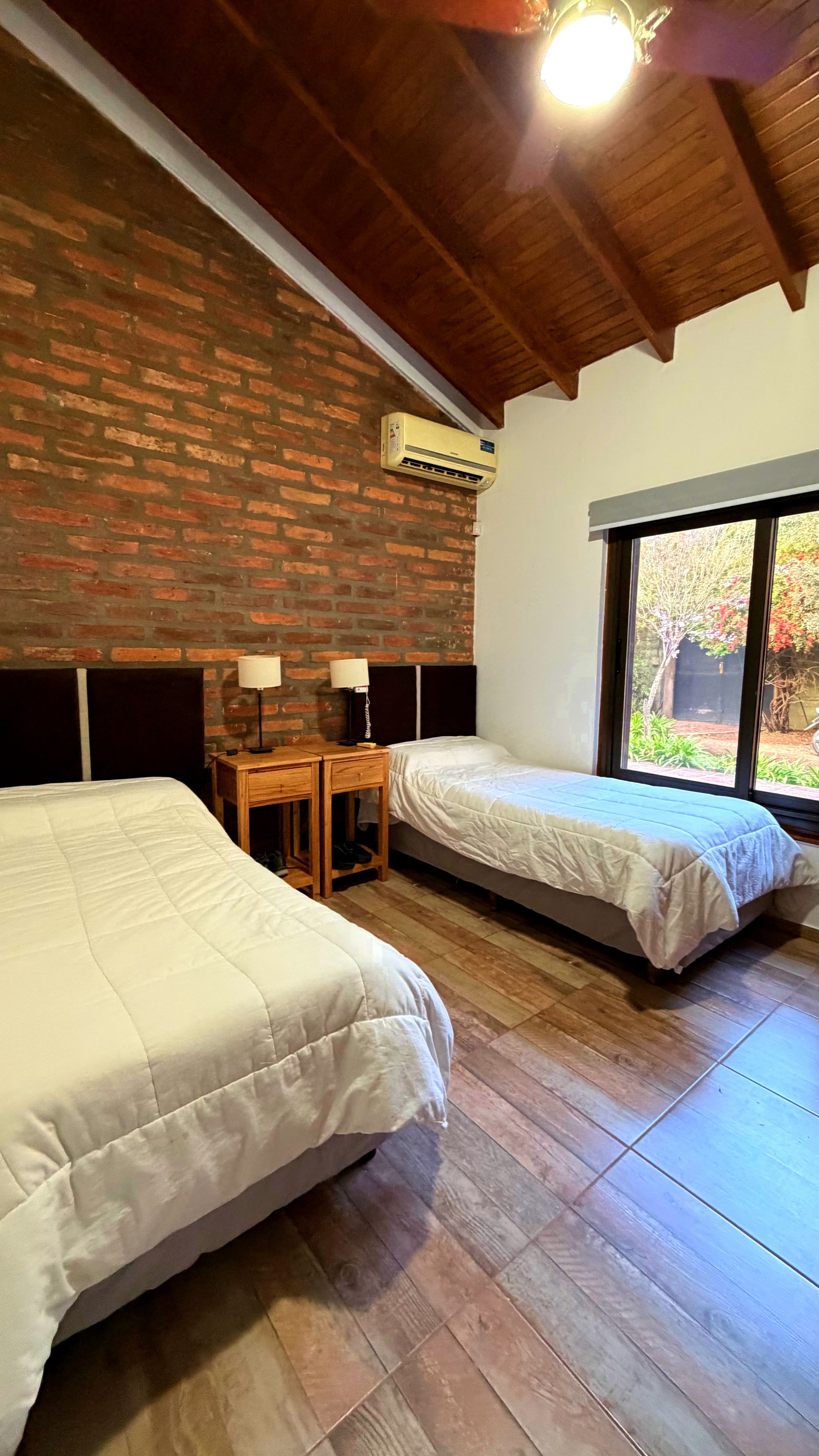 Habitación de ReCordis con pared de ladrillo y techo de madera