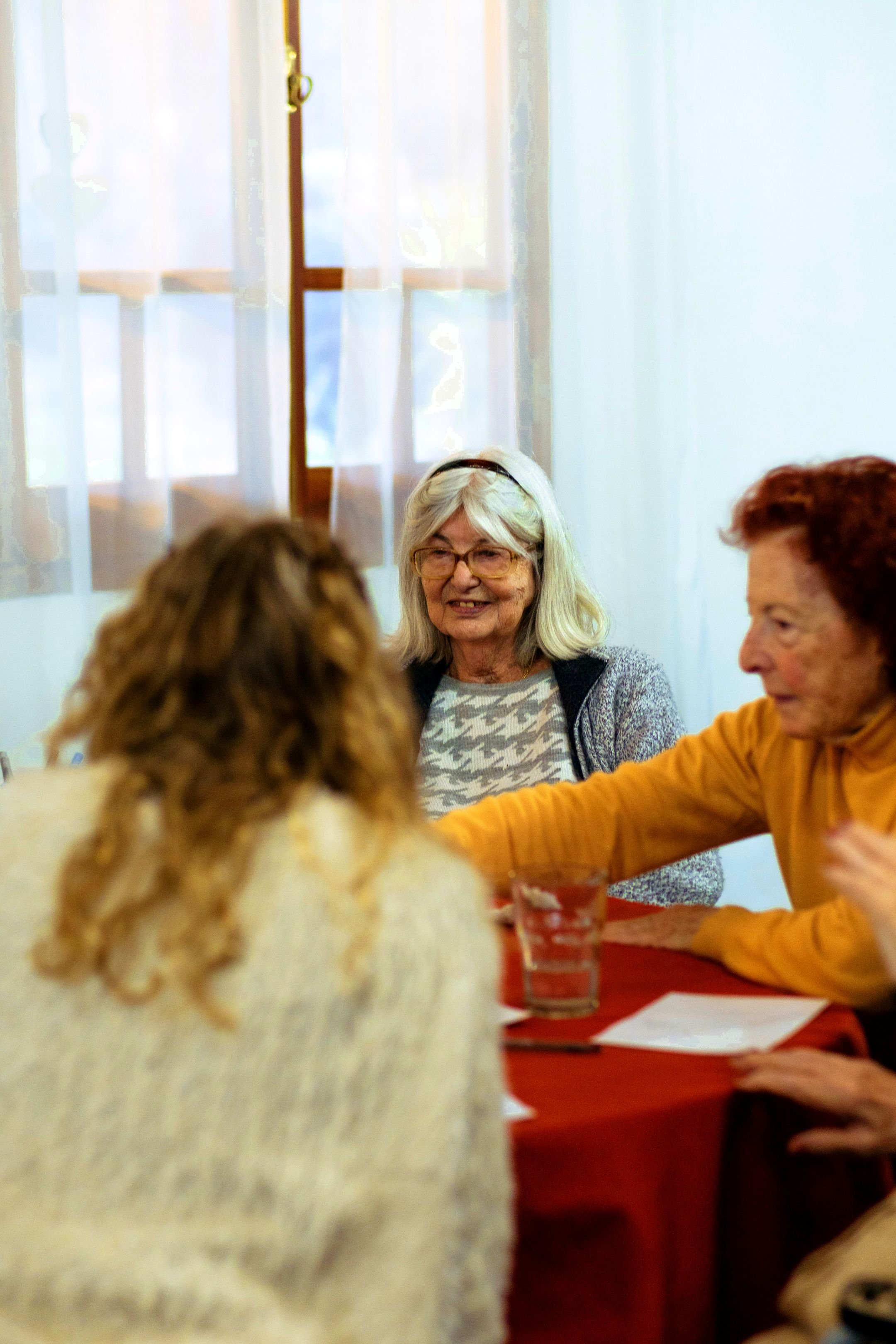 Tres residentes conversando alrededor de la mesa