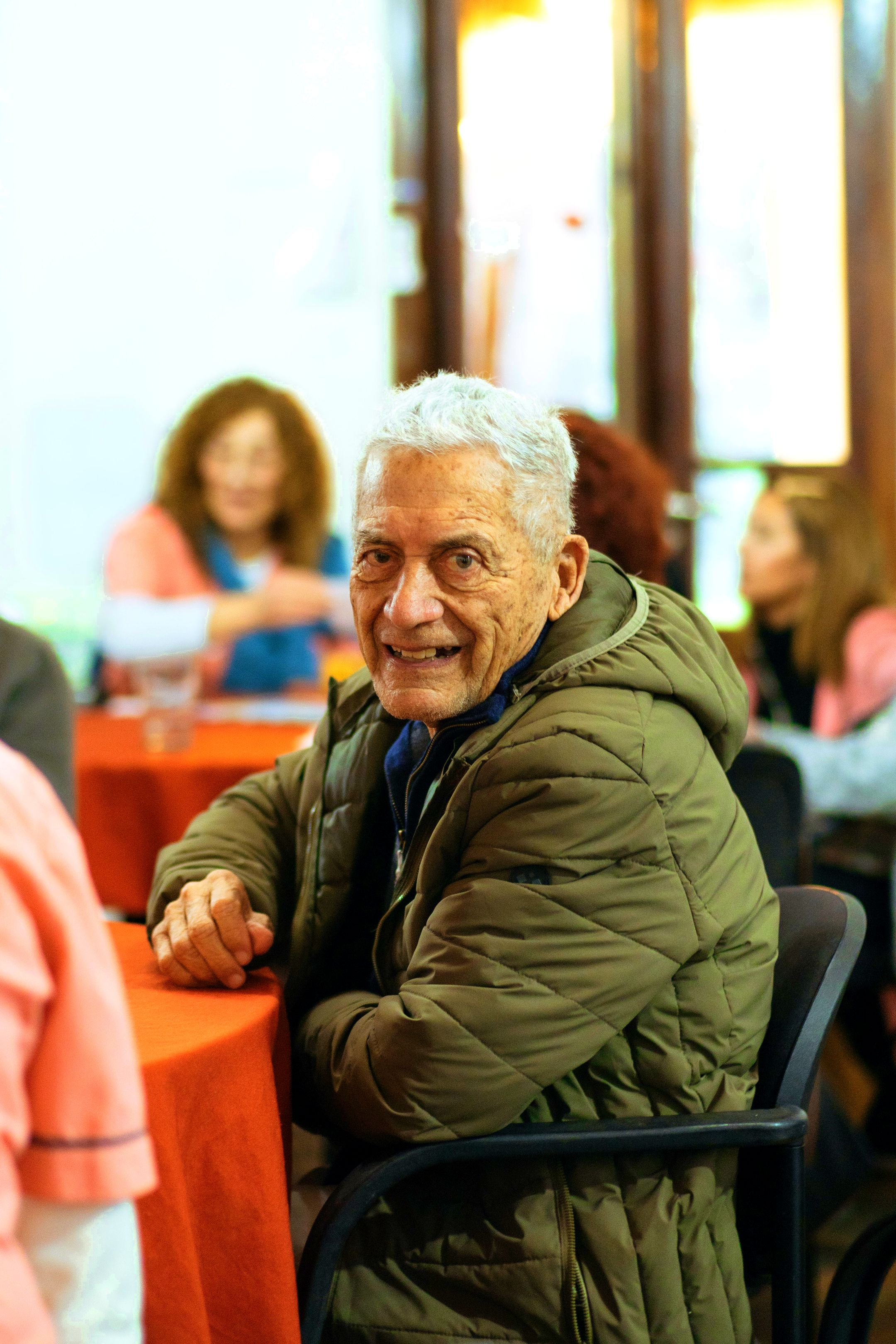 Un residente sonríe sentado a la mesa del taller