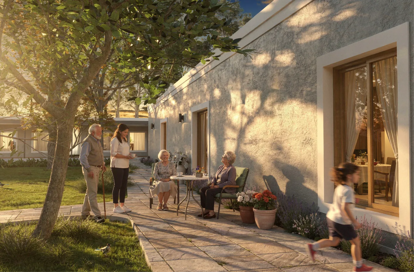 Render del patio de las habitaciones nuevas: el camino de piedra junto a la galería, con personas mayores tomando algo a la sombra de un árbol
